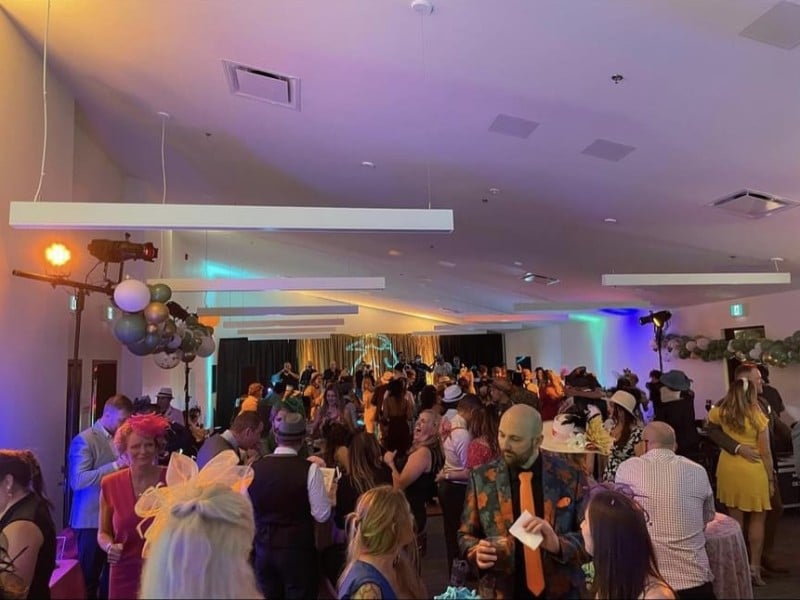 A crowd of people celebrate in Hollywood decor.