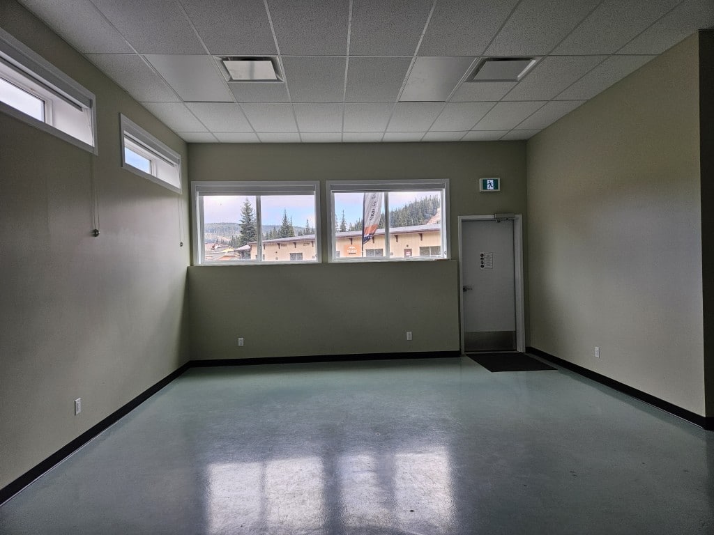 the inside of a community space, dimly lit with reflective floors and high windows.