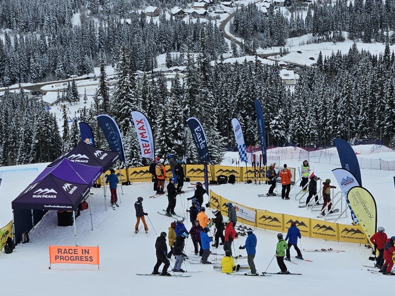 A crowd of skiers gather at the start gate for a race.