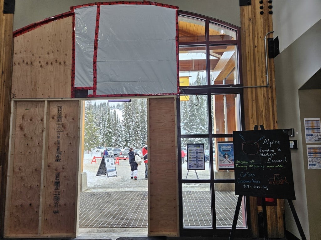 Village Day Lodge large glass doors boarded up, inside view.