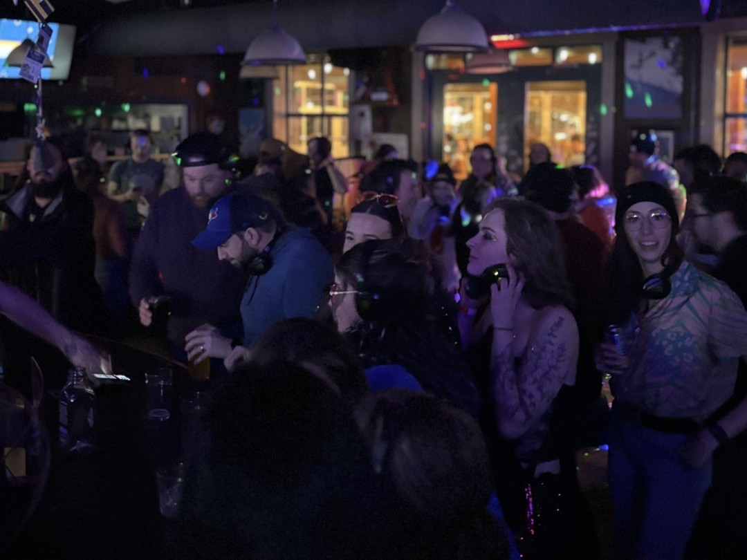 A crowd of people wearing personal headphones enjoy a silent disco at Bottoms.